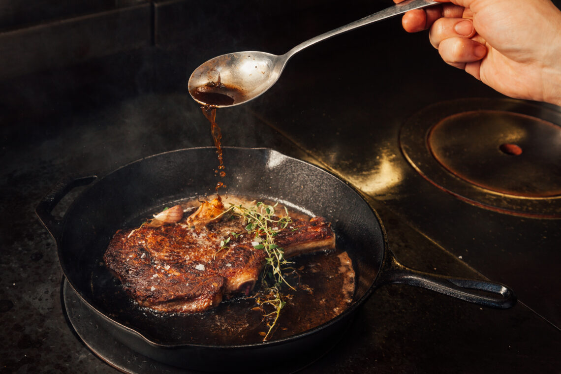 A perfectly seared steak in a cast-iron skillet, topped with melting garlic herb butter