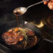 A perfectly seared steak in a cast-iron skillet, topped with melting garlic herb butter