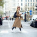 Woman holding coffee and walking down the street in the city