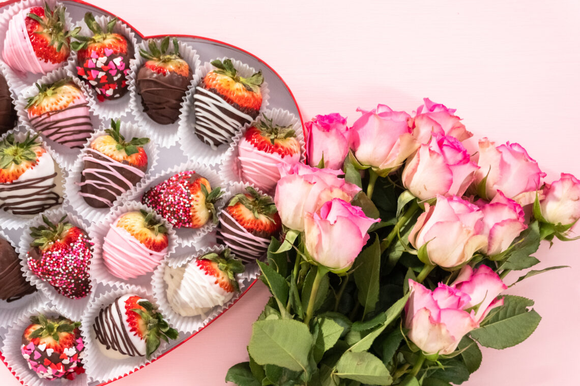 A plate of homemade chocolate-covered strawberries drizzled with white chocolate, perfect for Valentine’s Day