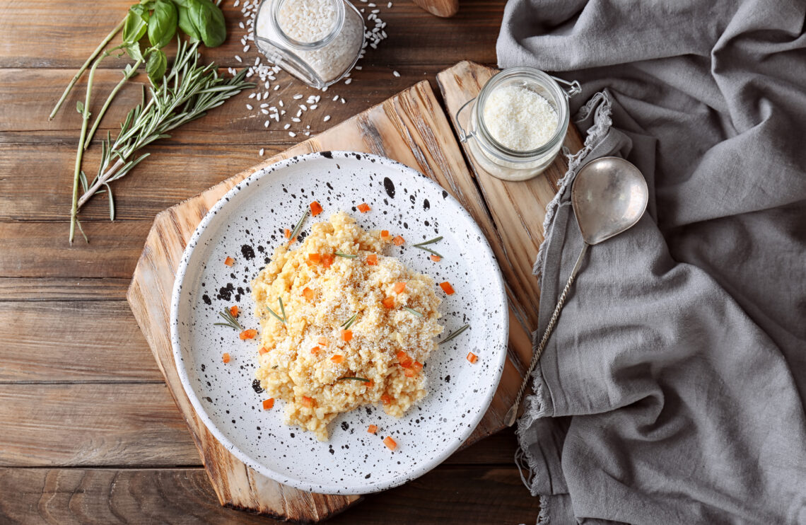 Plate with delicious risotto on wooden table